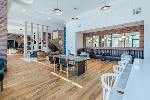 the gathering place at gardner village community room with tables and chairs at The Livano Tryon, North Carolina